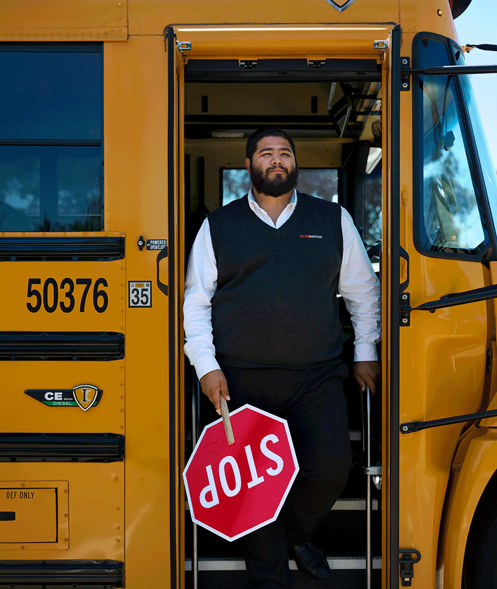 Sun Diego Charter team member holding a stop sign at a school bus entrance