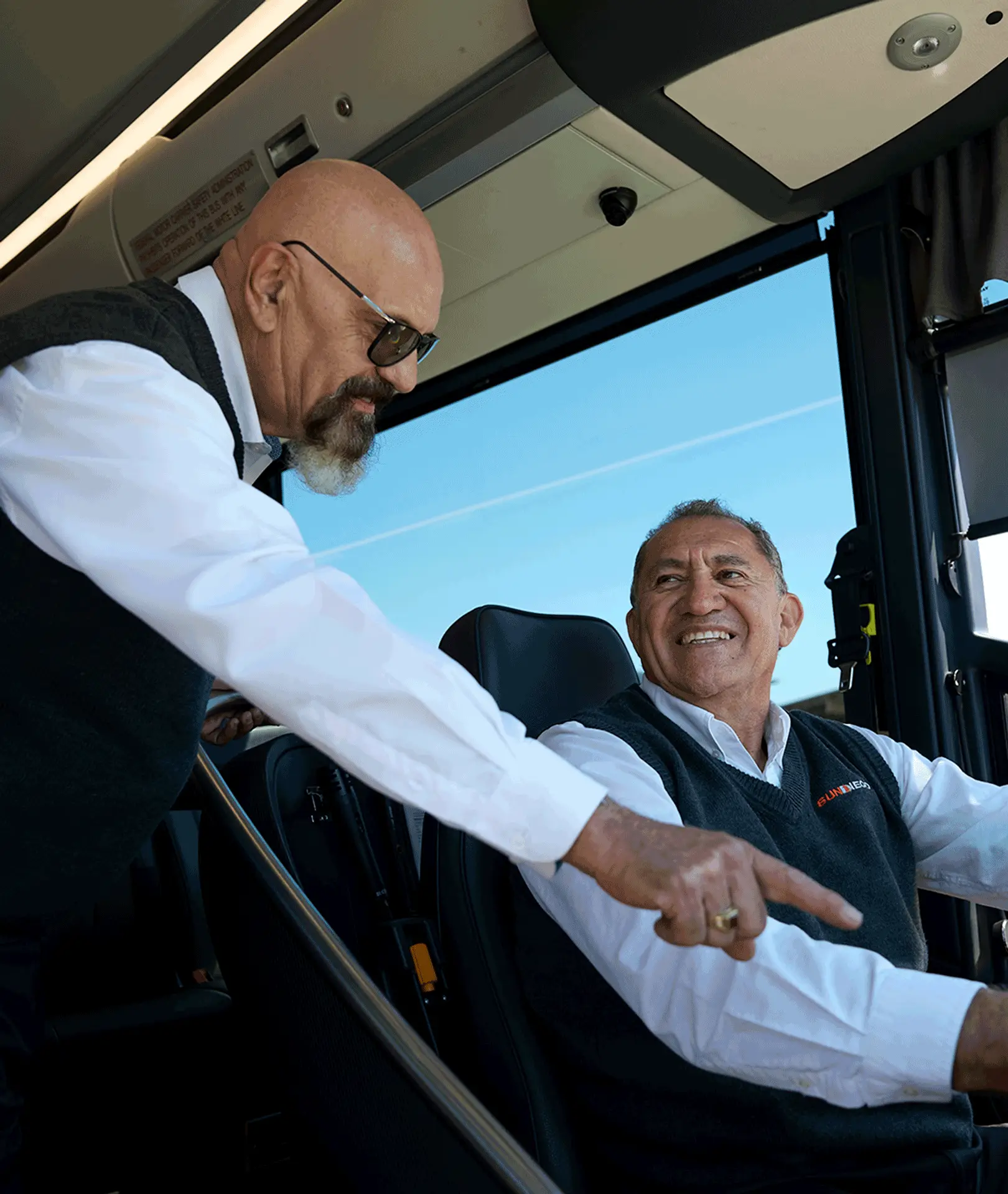 Two Sun Diego Charter team members talking at the motorcoach driver’s seat