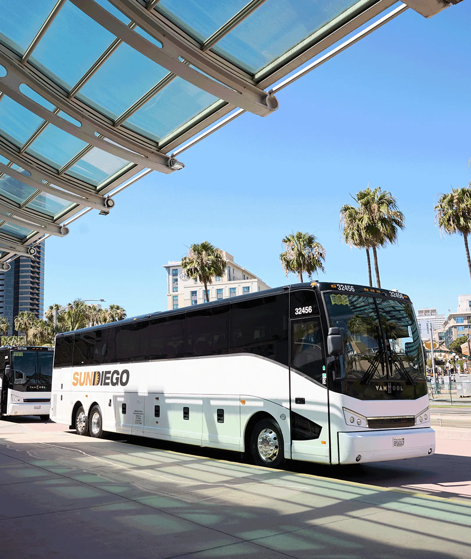 Sun Diego Charter motorcoaches parked beneath a terminal canopy
