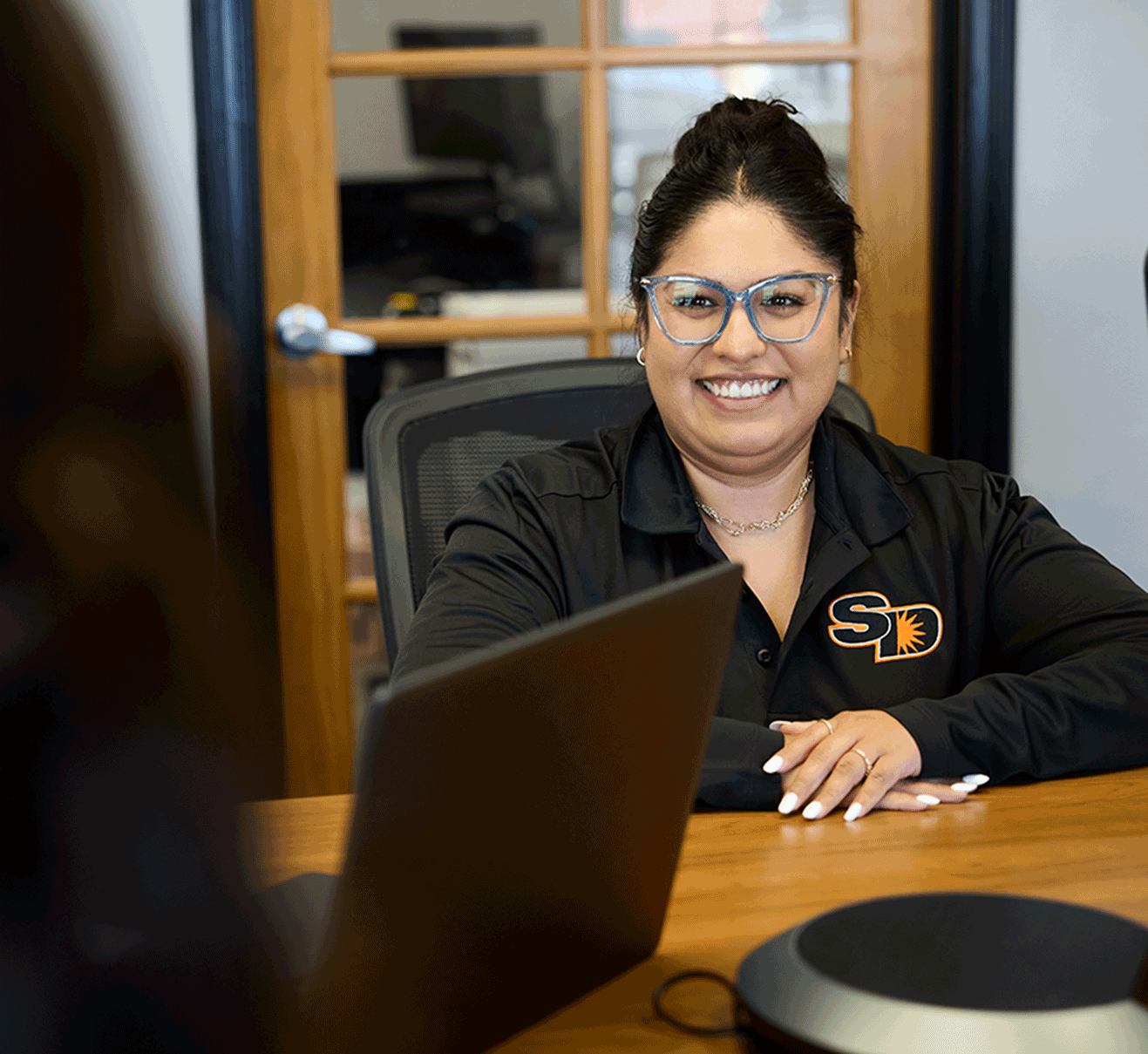Sun Diego Charter team member smiling behind a laptop