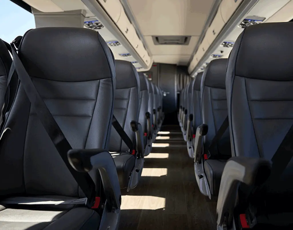 Motorcoach aisle lined with black reclining seats