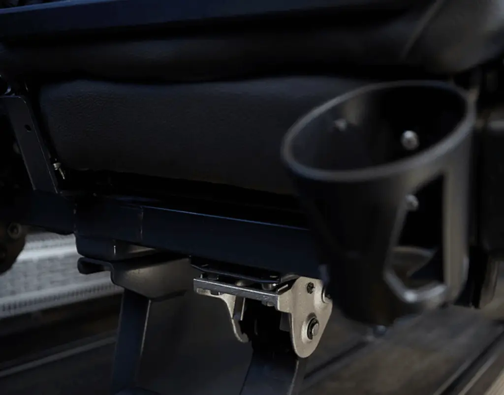 Cup holder and folded footrest on the back of a motorcoach seat