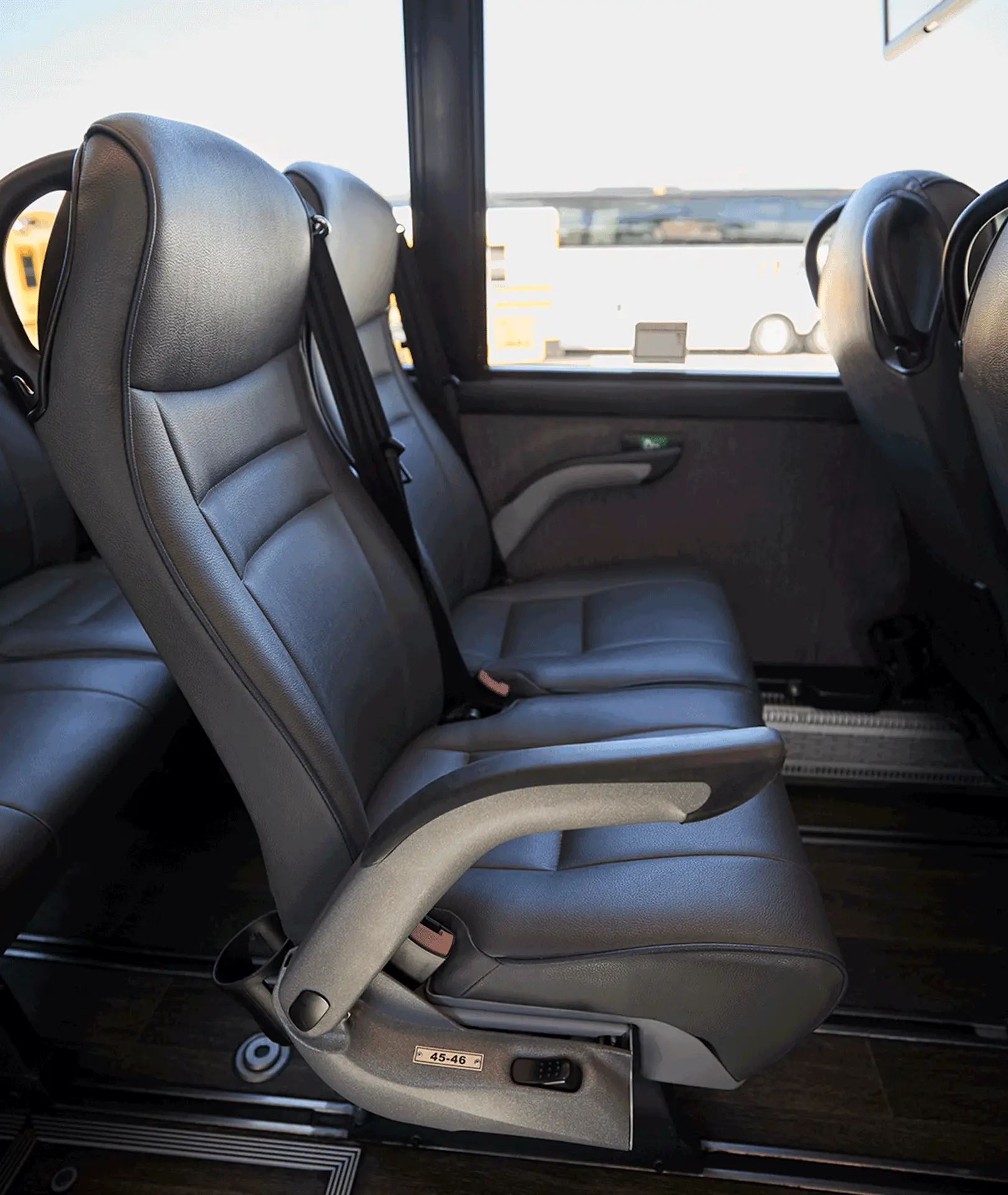 Black motorcoach passenger seats with armrests and seat belts