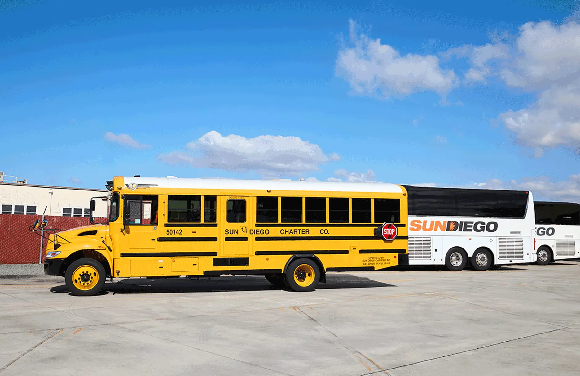 Yellow school bus parked in front of Sun Diego Charter motorcoaches