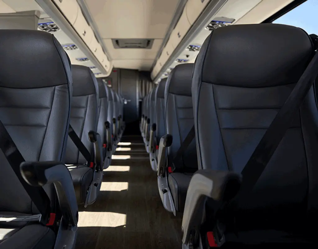 Motorcoach aisle lined with black reclining seats