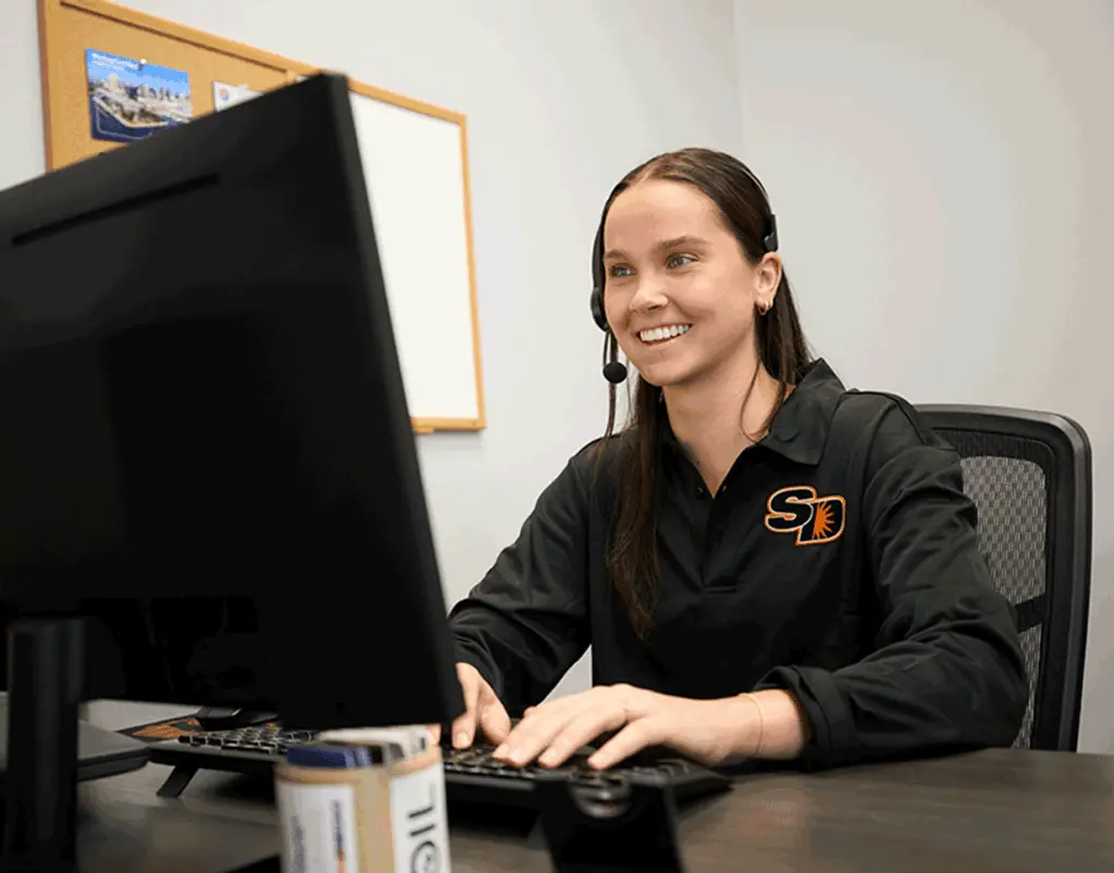 Sun Diego Charter team member wearing a headset at a computer