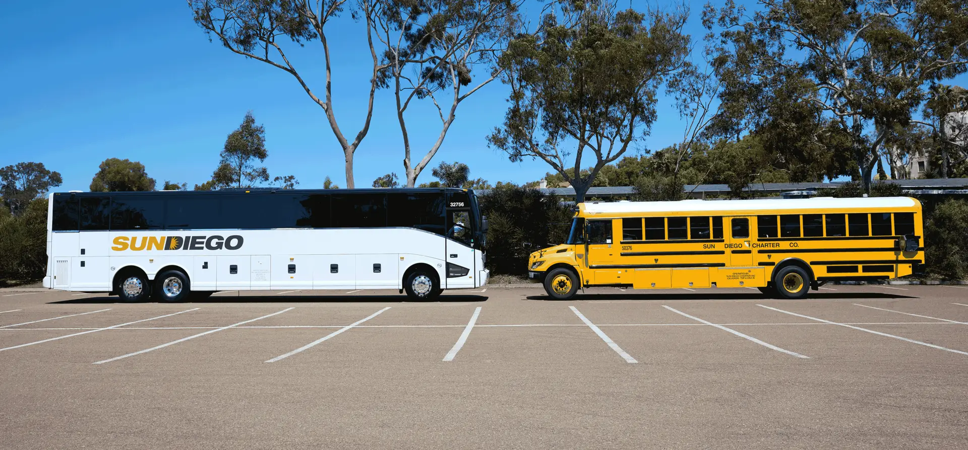 Sun Diego Charter motorcoach and yellow school bus parked side by side