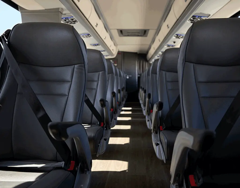 Motorcoach aisle lined with black reclining seats