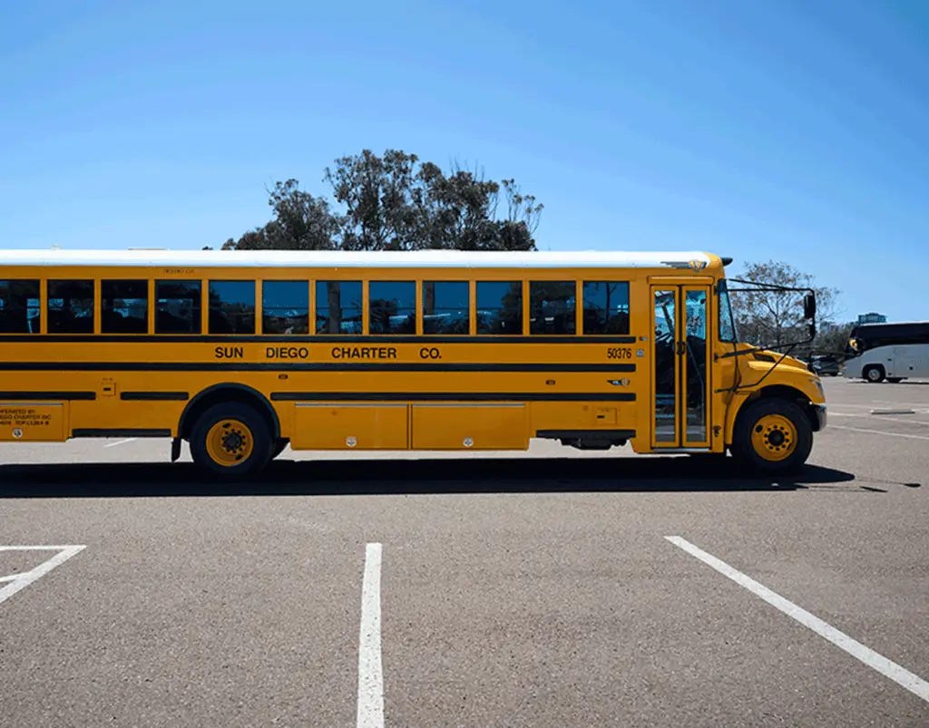 Side view of a yellow Sun Diego Charter school bus