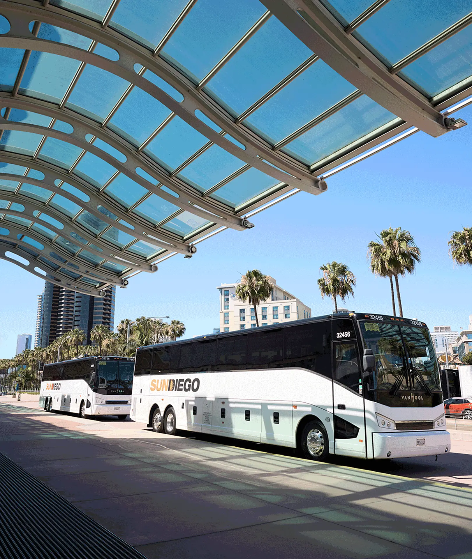 Sun Diego Charter motorcoaches parked beneath a terminal canopy