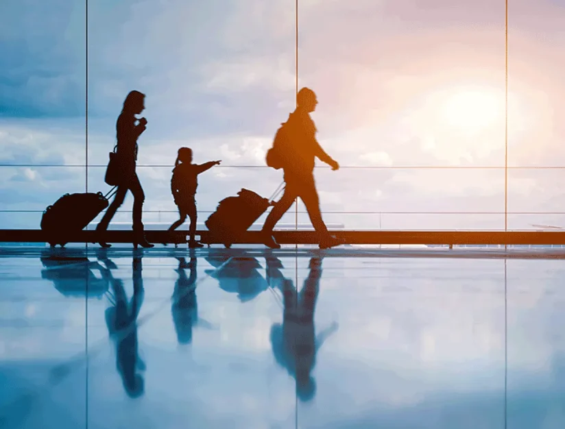 Travelers pulling suitcases through an airport terminal