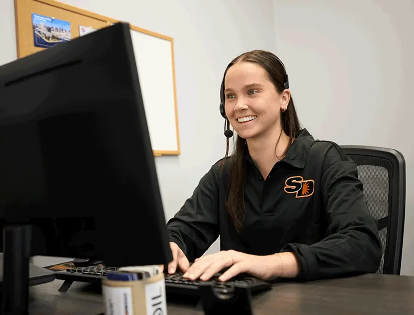 Sun Diego Charter team member wearing a headset at a computer