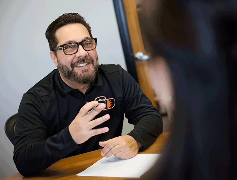 Sun Diego Charter team member talking with a person across a desk
